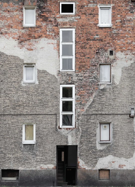 Image d'un immeuble délabré avec plusieurs fenêtres